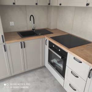 Współczesna przestronna kuchnia, w odcieniach szarosci i drewna