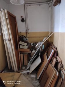 pomieszczenie przed remontem, drewniane deski i stare drzwi